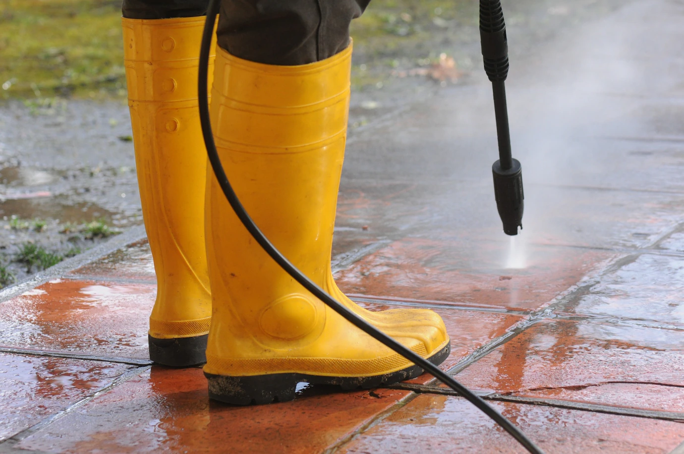 Pressure cleaning an exterior paved surface with a high pressure washer